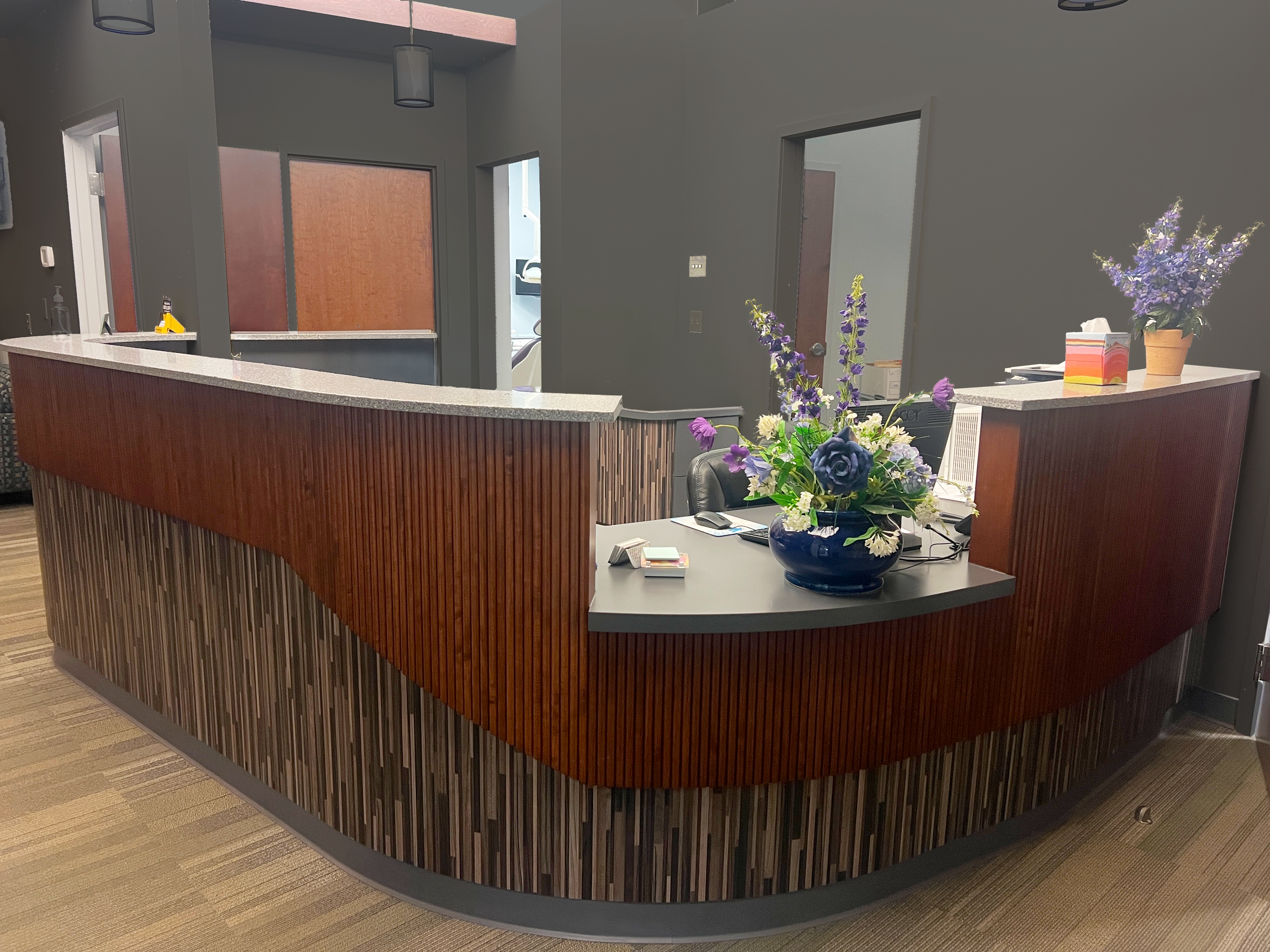 Interior office view of The Buffalo Dentist in Buffalo NY showing a wooden desk in the reception area of the dental office